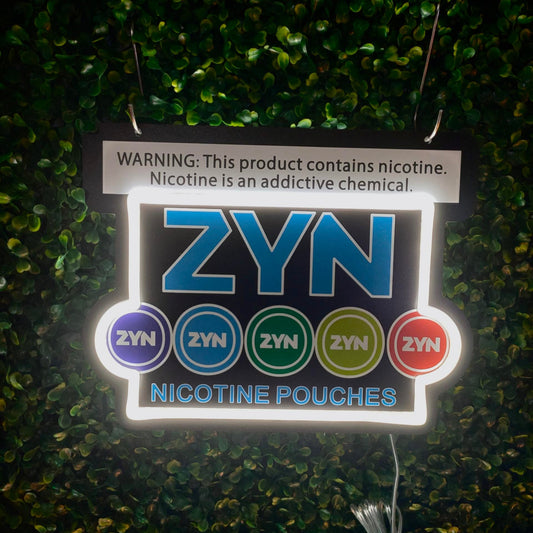 ZYN nicotine pouches packaging with warning label on a green textured background